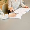 Two women sat at a desk going over paperwork
