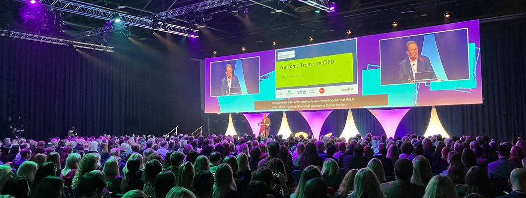 Photo of a packed conference room at the CIPD's Annual Conference in Manchester. The Audience are watching Peter Cheese talk and he is also on screen. 