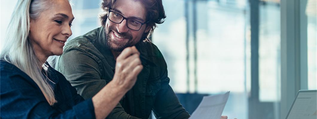 older woman speaking to a younger man in an office setting
